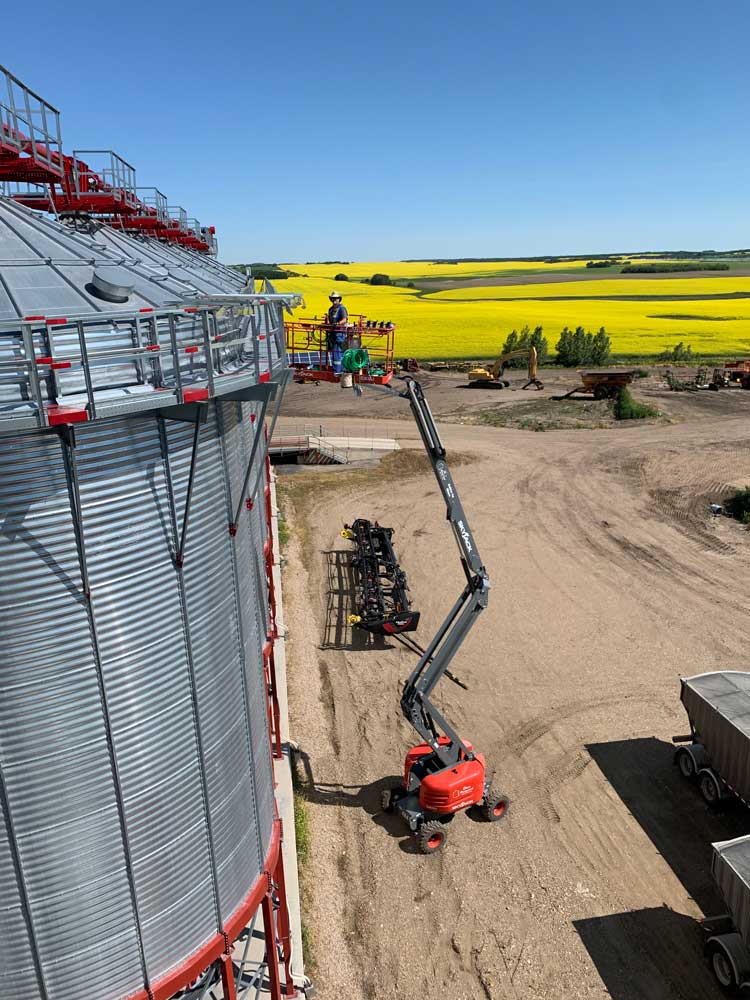 Kevin Clews on manlift at top of grain bin